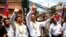 Cambodia&#39;s opposition leader Sam Rainsy, center, of the Cambodia National Rescue Party waves along with his party Vice President Kem Sokha, third from left, during a march in Phnom Penh, Cambodia, Sunday, March 30, 2014. 