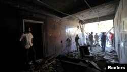 Security personnel inspect damage in the Swedish consulate after a car bomb exploded at its entrance, in Benghazi, Oct. 11, 2013. 