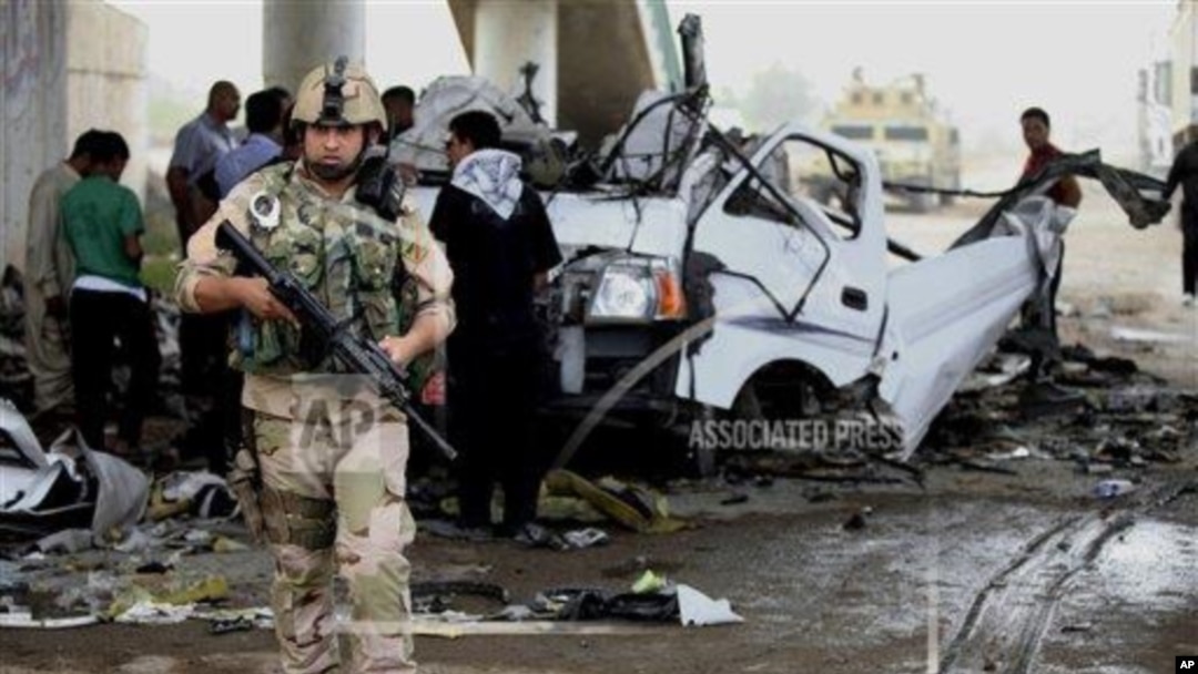 Pasukan keamanan Irak dan warga setempat memeriksa lokasi serangan bom mobil di distrik Husseiniyah, pinggiran Baghdad, Senin (6/5).