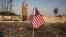 FILE - An American flag stands in front of a home destroyed after a wildfire tore through Santa Rosa, California, Oct. 15, 2017.