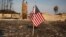 FILE - An American flag stands in front of a home destroyed after a wildfire tore through Santa Rosa, Calif., Oct. 15, 2017.