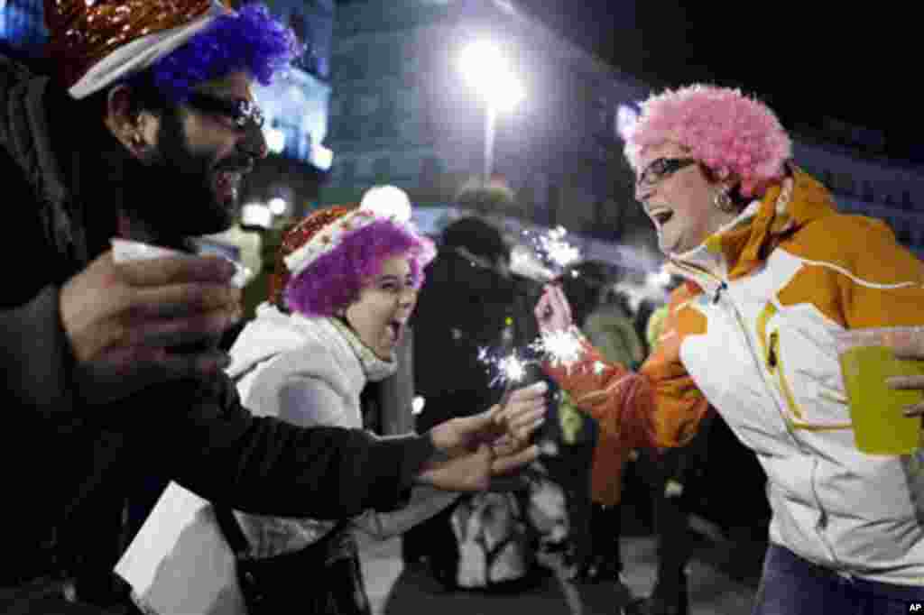 People celebrate the New Year in Madrid's Puerta del Sol square, Spain, 01 Jan 2011. (AP Image)