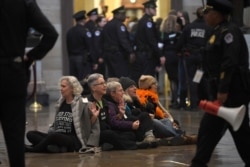 Protesters demonstrate against President Donald Trump by sitting on the floor of the Rotunda on Capitol Hill in Washington, Feb. 5, 2020.