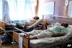 Wounded Afghans lie in bed at a hospital after a bomb attack on a local mosque in Kandahar province, south of Kabul, Afghanistan, Sept. 28, 2019.