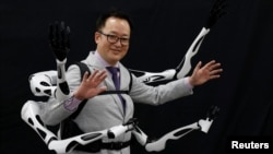 Masahiko Inami of the University of Tokyo poses with the wearable "Jizai Arms" robot arms at his lab during its demonstration in Tokyo, Japan, June 22, 2023. (REUTERS/Kim Kyung-Hoon)