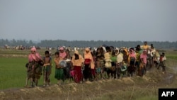 Displaced Rohingya refugees from Rakhine state in Myanmar carry their belongings as they flee violence, near Ukhia, near the border between Bangladesh and Myanmar on September 4, 2017. - A total of 87,000 mostly Rohingya refugees have arrived in Banglades