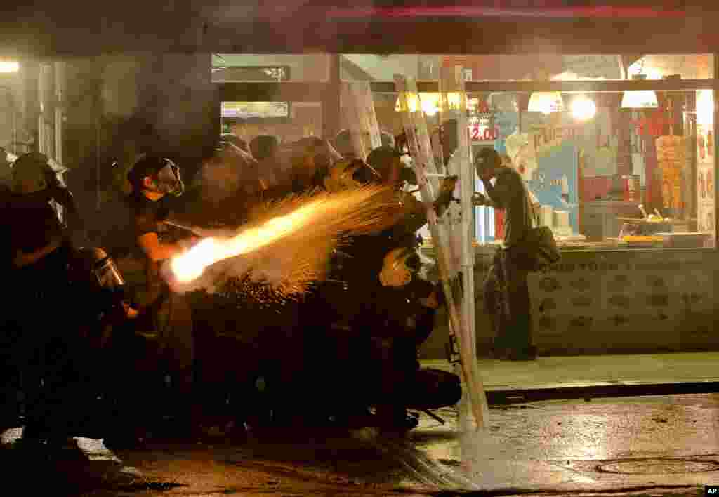 Turkish riot police fire tear gas after chasing protestors out of Gezi Park in Istanbul, Saturday, June 15, 2013.