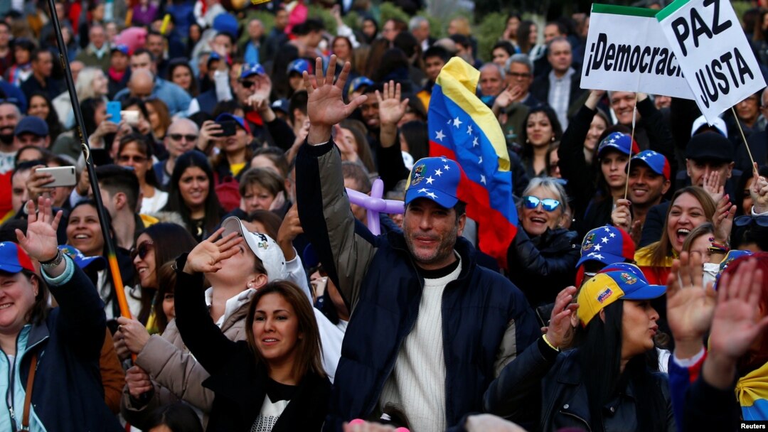 FILE - Protesters gather to call for humanitarian aid for Venezuela, in Madrid, Spain, Feb. 23, 2019.