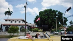 Tourists riding in a vintage car pass in front of Canada's Embassy in Havana, Cuba, May 9, 2019.