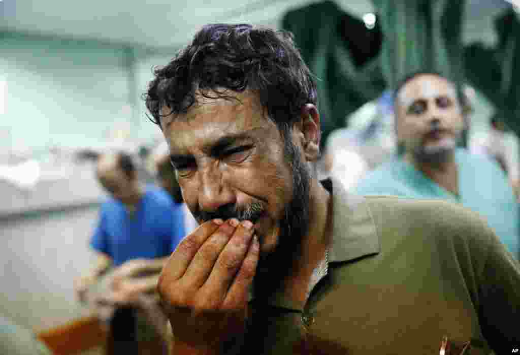 A Palestinian man cries after bringing a child, wounded in an Israeli strike on a compound housing a U.N. school in Beit Hanoun, in the northern Gaza Strip, to the emergency room of the Kamal Adwan hospital in Beit Lahiya.