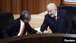 Jose Alejandro Luna Ramos (R), president of the Federal Electoral Tribunal (TRIFE), talks to magistrate Flavio Galvan during a public session in Mexico City August 31, 2012. Mexico's electoral tribunal officially named Enrique Pena Nieto as president-elec