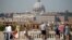 FILE - Tourists take pictures of Saint Peter's Basilica from Pincio terrace in downtown Rome, Italy, Aug. 3, 2017. 