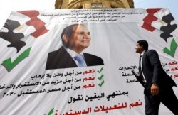A man walks in front of a banner reading, "Yes to the constitutional amendments, for a better future", with a photo of the Egyptian President Abdel Fattah al-Sisi before the referendum on constitutional amendments in Cairo, Egypt April 16, 2019.