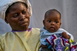 Two-month-old Lahya Kathembo is carried by a nurse waiting for test results at an Ebola treatment center in Beni, Congo, July 17, 2019.