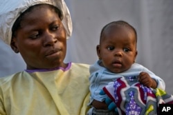 Two-month-old Lahya Kathembo is carried by a nurse waiting for test results at an Ebola treatment center in Beni, Congo, July 17, 2019.