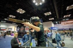 A woman uses a virtual reality based firearms simulator at the National Rifle Association's annual meeting, in Indianapolis, Indiana, April 28, 2019.