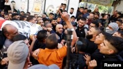 FILE —People attend the funeral of five Palestinian fighters who were killed in an Israeli air strike in the Balata Camp, in Nablus, in the Israeli-occupied West Bank, November 18, 2023