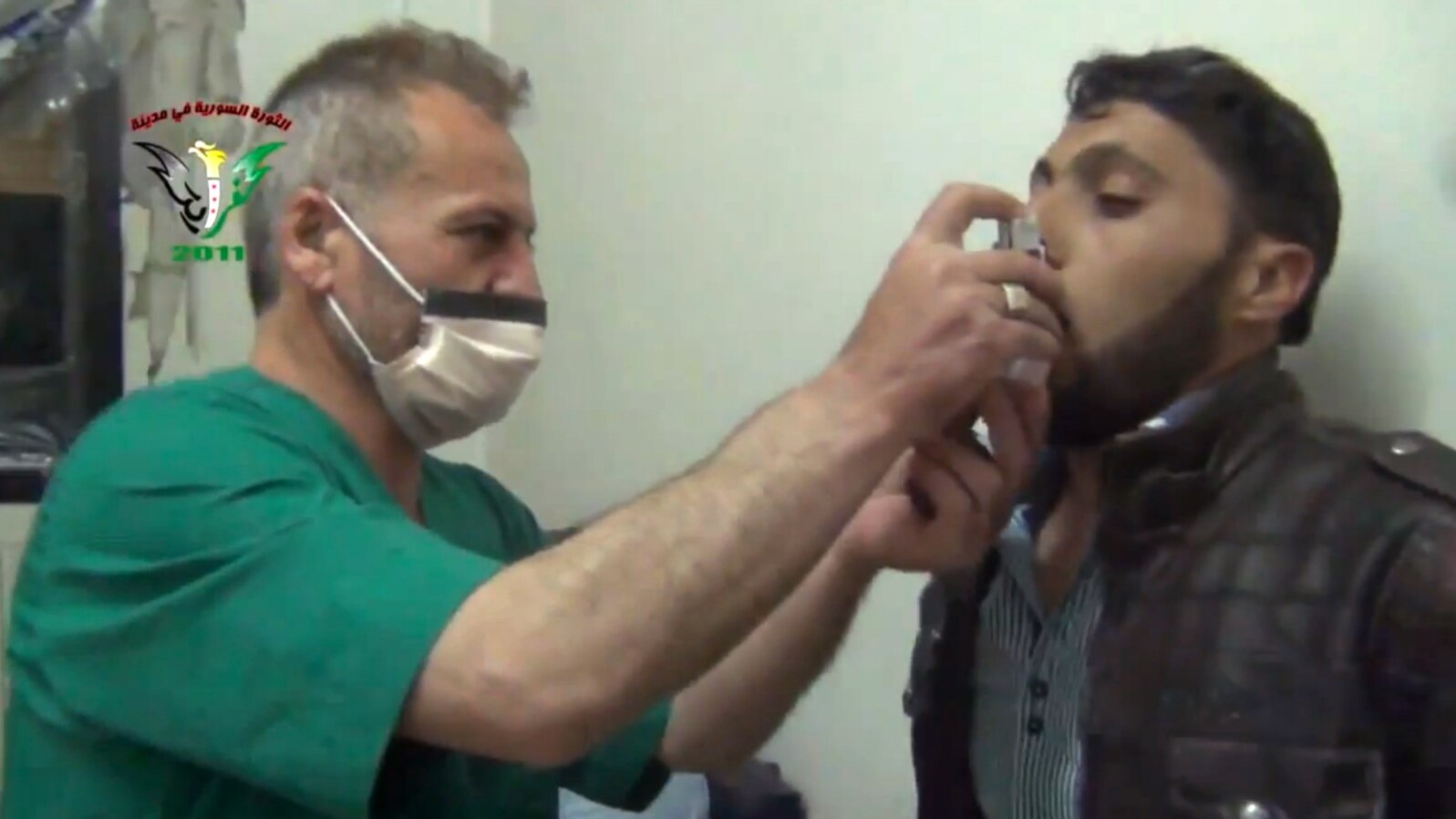 FILE - This video image from an anti-Bashar Assad activist group shows a Syrian man being treated with an inhaler in Kfar Zeita, north of Damascus, after what witnesses said was a chlorine gas attack, April 18, 2014.
