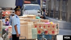 Nhân viên hải quan Việt Nam bên cạnh hàng hóa được mua bán tại cửa khẩu Tây Thanh, Lạng Sơn (D. Schearf/VOA)