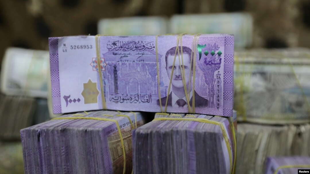 FILE - Syrian pounds are pictured inside an exchange currency shop in Azaz, Syria, Feb. 3, 2020. Rising prices and a drop in the currency's value have pushed ordinary Syrians to vent their anger in recent protests.