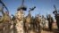Iraqi fighters from the Shiite Muslim Al-Abbas popular mobilisation unit hold up their weapons in the area surrounding the village of Nukhayb in the embattled Anbar province west of the capital Baghdad, May 19, 2015.