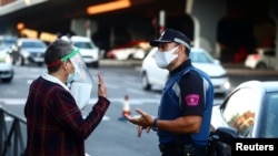 A local police officer speaks with a woman in the Vallecas neighbourhood during the first day of a partial lockdown between and within areas in six districts amid the outbreak of the coronavirus disease (COVID-19) in Madrid, Spain, Sept. 21, 2020.