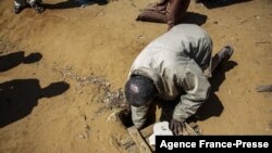 Jonarson Revoria, 73 ans, un agriculteur, montre un petit bassin creusé dans le sol pour recueillir l'eau de pluie dans le village d'Ankilidoga, commune de Sampona, Madagascar, le 31 août 2021. 