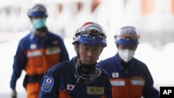 Japanese rescue workers walk past the rubble of the CTV building that houses an English language school in Christchurch, New Zealand, Feb. 24, 2011.