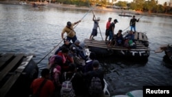 People belonging to a caravan of migrants from Honduras en route to the United States, cross the Suchiate river to Mexico from Tecun Uman, Guatemala, Jan. 18, 2019. 