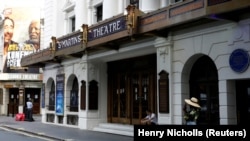 Orang-orang berdiri di sebelah St Martin's Theatre di London's West End di London, Inggris, 13 Agustus 2020. (Foto: REUTERS/Henry Nicholls)