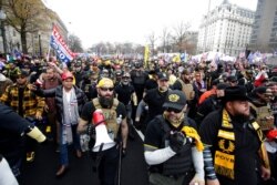 FILE - Supporters of President Donald Trump, many who are wearing attire associated with the Proud Boys, attend a rally at Freedom Plaza in Washington, Dec. 12, 2020.