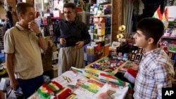 FILE - A bazaar vendor selling patriotic and pro-independence ware talks with a customer in Irbil, Iraq, Aug. 24, 2017. Despite calls from Baghdad and the United States to postpone the vote, Iraq’s semiautonomous Kurdish region is pressing ahead with plans to hold a referendum on independence Sept. 25.