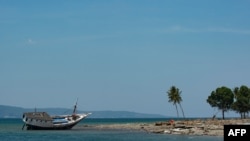 A stranded boat is seen on the coast of Central Sulawesi, Indonesia, Oct. 3, 2018, after an earthquake. A 7.1 magnitude temblor hit nearby North Maluku province Thursday.