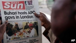 FILE - A man reads a story about Nigeria's President Muhammadu Buhari after the government released a photo of Buhari more than two months after he left for London for medical treatment, in Lagos, July 24, 2017.