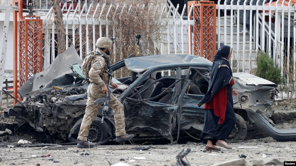 资料照片:阿富汗安全部队成员检查喀布尔一处爆炸现场被炸毁的汽车。(2020年12月20日)