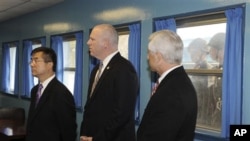 U.S. Secretary of Commerce Gary Locke (L) , U.S. Rep. Joseph Crowley, D-N.Y., and U.S. Representatives David Reichert, R-Wash., visit the U.N. Command Military Armistice Commission meeting room as North Korean soldiers look through a window at the border 