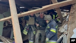 ARCHIVO - En esta imagen proporcionada por el Servicio Ucraniano de Emergencias, trabajadores de emergencias ayudan a un hombre herido después de que un ataque de misil ruso causara graves daños en edificio residenciales cerca de Krivói Rog, Ucrania, el 8 de enero de 2024. 