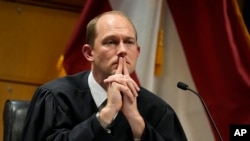 FILE - Fulton County Superior Judge Scott McAfee presides in court, Feb. 27, 2024, in Atlanta, Georgia. The judge overseeing the election interference case dismissed some of the charges against former President Donald Trump on March 13, 2024, but others remain.