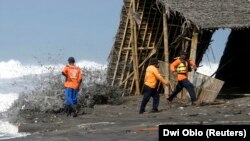 Petugas penyelamat berlari saat gelombang tinggi menghantam garis pantai di Pantai Parangtritis, Yogyakarta, 19 Mei 2007. (Foto: REUTERS/Dwi Oblo)