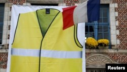 A giant banner showing a yellow vest, as a symbol of French drivers' protest against higher fuel prices, is displayed ahead of a nationwide protest on the facade of the town hall in Morbecque, France, Nov. 15, 2018. 