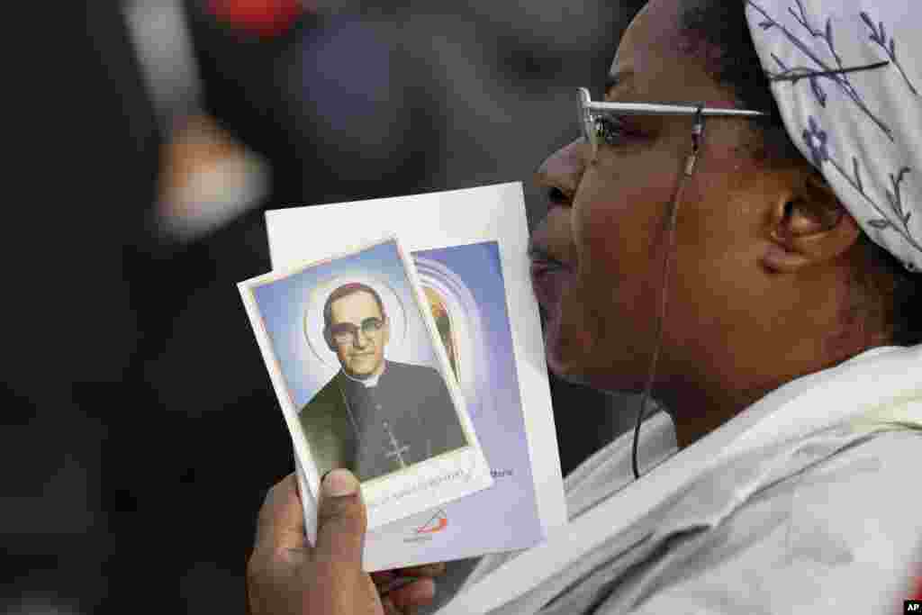 Una mujer sostiene una imagen del arzobispo salvadoreño Oscar Romero, en la Plaza de San Pedro en el Vaticano, el domingo 14 de octubre de 2018, durante la ceremonia de canonización del asesinado Romero. También fueron elevados a la santidad el papa Paulo VI y otros cinco beatos.(Foto AP / Andrew Medichini)