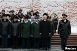 Presiden Rusia Vladimir Putin dan Menteri Pertahanan Sergei Shoigu, saat upacara peletakan karangan bunga menandai Hari Pembela Tanah Air di Makam Prajurit Tak Dikenal dekat Tembok Kremlin di Moskow, Rusia, 23 Februari 2024. (Foto: Sputnik/Alexander Kazakov via REUTERS)