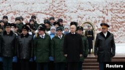 Presiden Rusia Vladimir Putin dan Menteri Pertahanan Sergei Shoigu, usai upacara peletakan karangan bunga menandai Hari Pembela Tanah Air di Makam Prajurit Tak Dikenal dekat Tembok Kremlin di Moskow, Rusia, 23 Februari 2024. (Sputnik/Alexander Kazakov/Pool via REUTERS)