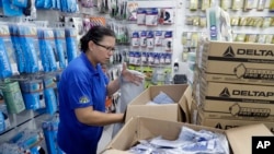 A medical supply store worker organizes masks that customers are buying as a precaution against the spread of the new coronavirus COVID-19, in Sao Paulo, Brazil, Feb. 26, 2020.