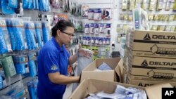 A medical supply store worker organizes masks that customers are buying as a precaution against the spread of the new coronavirus COVID-19, in Sao Paulo, Brazil, Feb. 26, 2020.