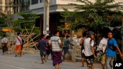 Anti coup protesters run as riot policemen and soldiers crack down on a demonstration and detain protesters in Mandalay, Myanmar, March 23, 2021. 