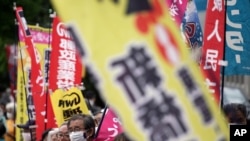 People chant slogans against government's decision to start releasing massive amounts of treated radioactive water from the wrecked Fukushima nuclear plant into the sea, during a rally outside the prime minister's office in Tokyo Tuesday, April 13,…