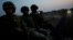FILE - Soldiers sit atop a military vehicle as they arrive for an operation to destroy a poppy field in the municipality of Coyuca de Catalan, Mexico, April 18, 2017.