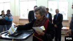 Žena ubacuje dva listića na jednom od tri biračka mesta na kojima su izbori ponovo održani