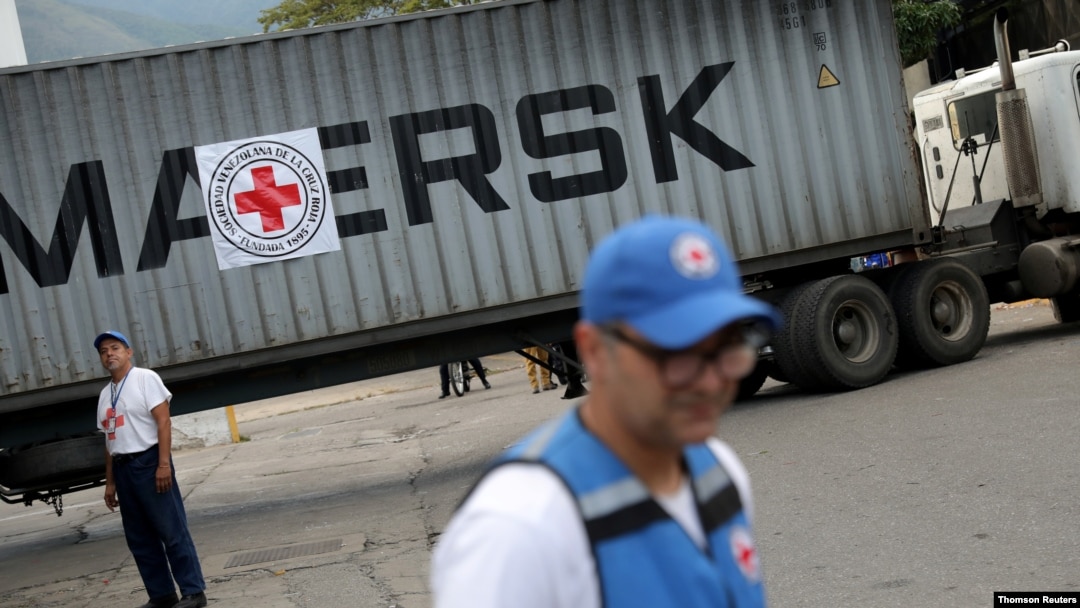 Volonteri stoje pored kamiona sa oznakom Međunarodne federacije društava crvenog krsta i crvenog polumeseca, koji je dovezao humanitarnu pomoć, u Karakasu, Venecuela, 31. jula 2019.